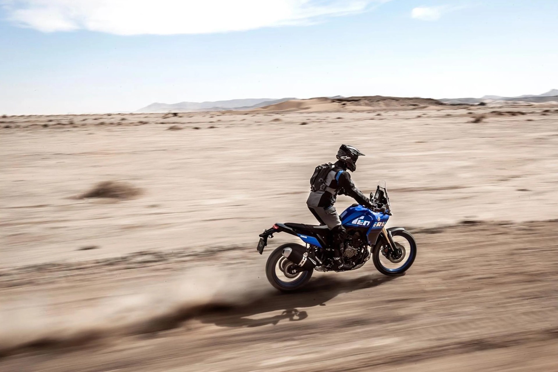 person riding a motorcycle through the desert