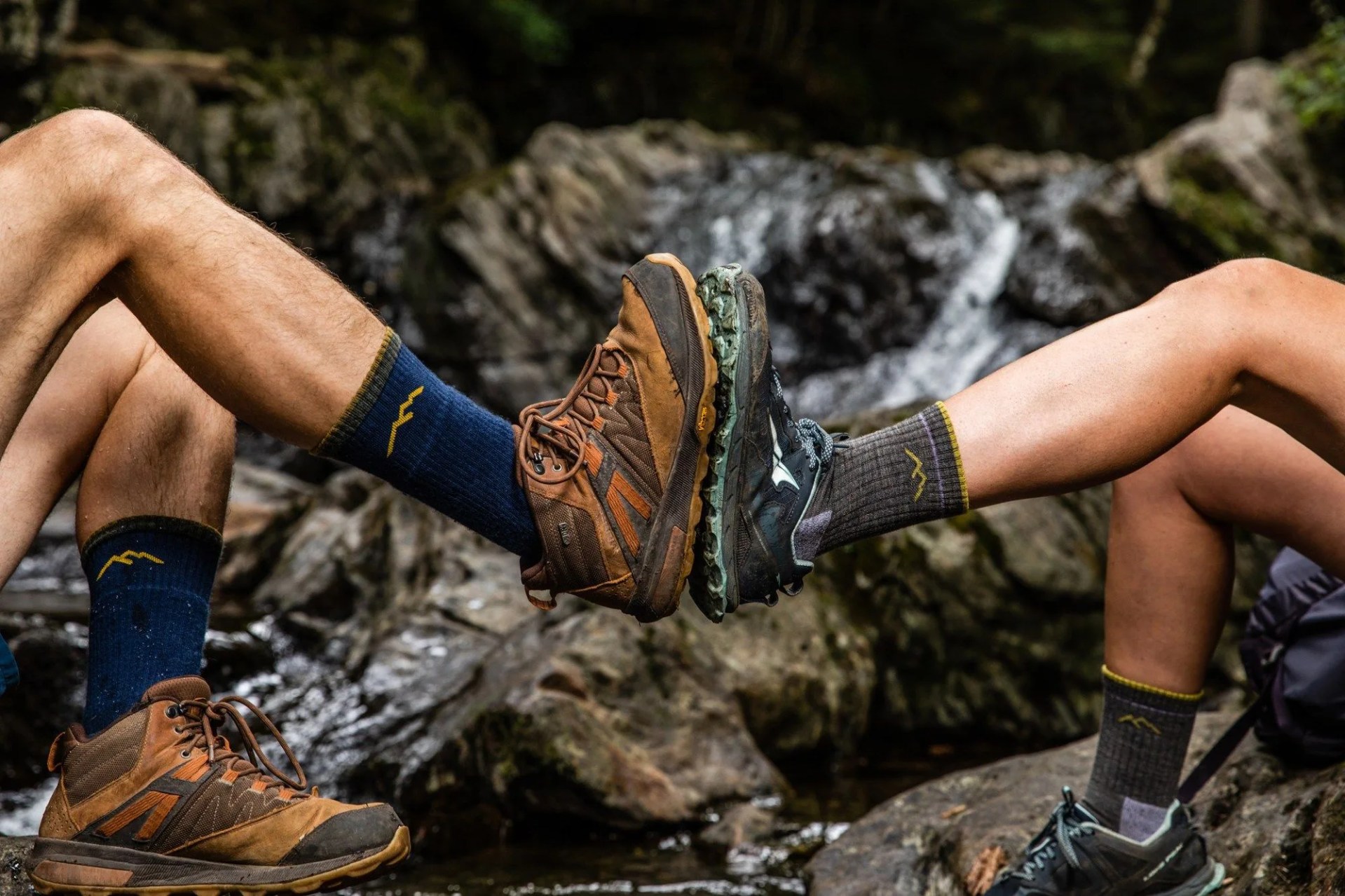 two legs meeting wearing hiking shoes and socks