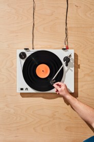 a hand putting on a record on a turntable