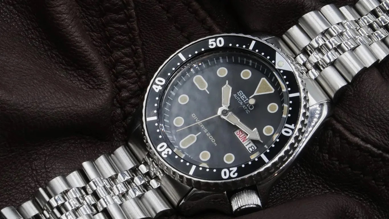 seiko dive watch on a forstner bracelet against a leather background