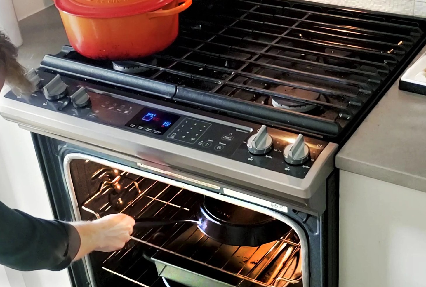 man puts oiled cast iron pan in oven