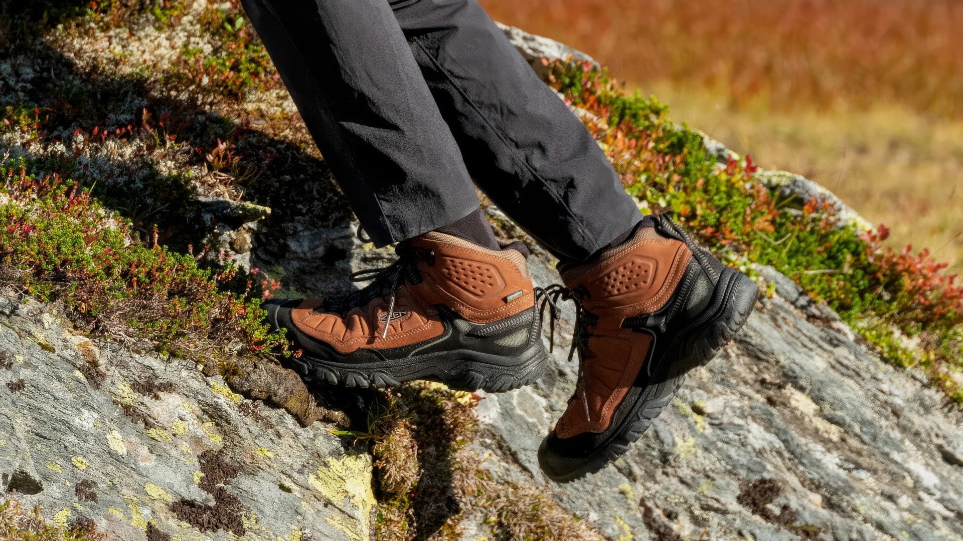 brown boot hiking over rock