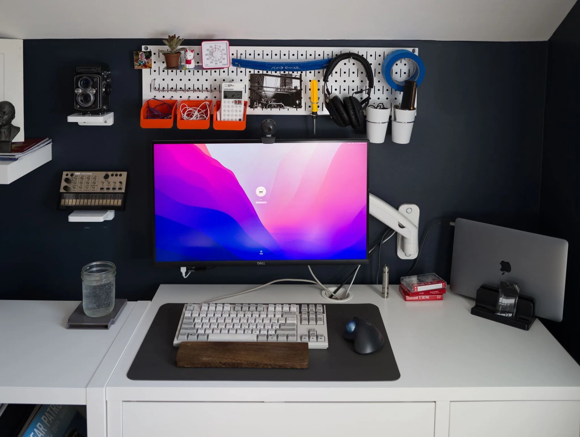 a computer monitor attached to a wall via a wall arm