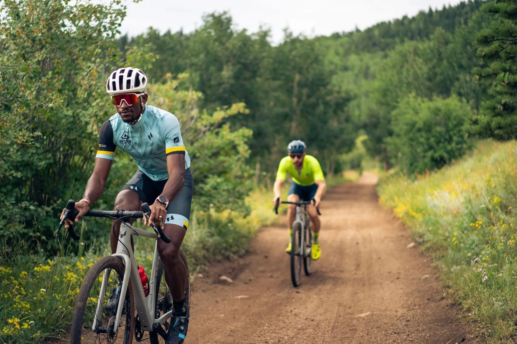 men riding gravel bikes on a dirt road