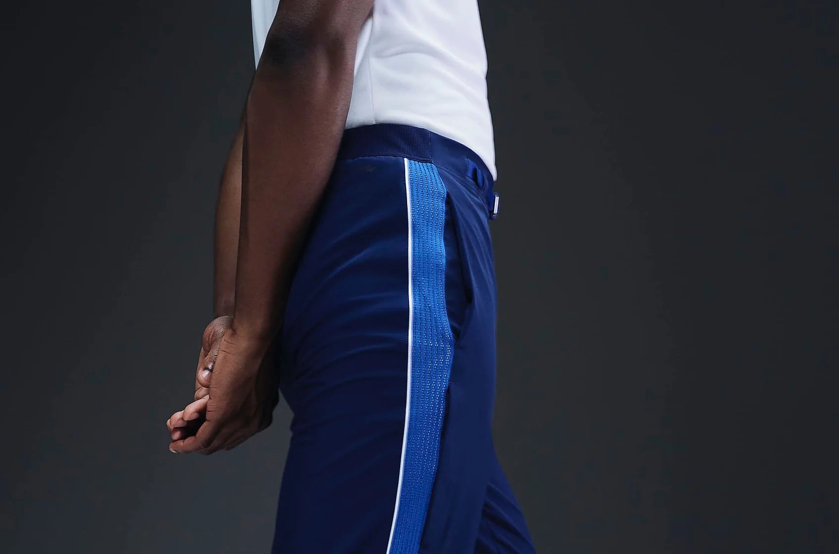 Nike Team USA 2024 Olympic Medal Podium pants shown being worn by a black male athlete wearing a white t-shirt from the side