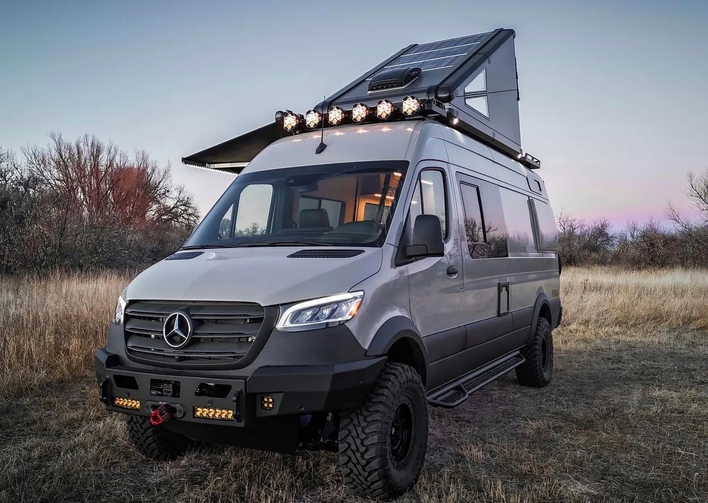 camper van with rooftop tent parked in a field