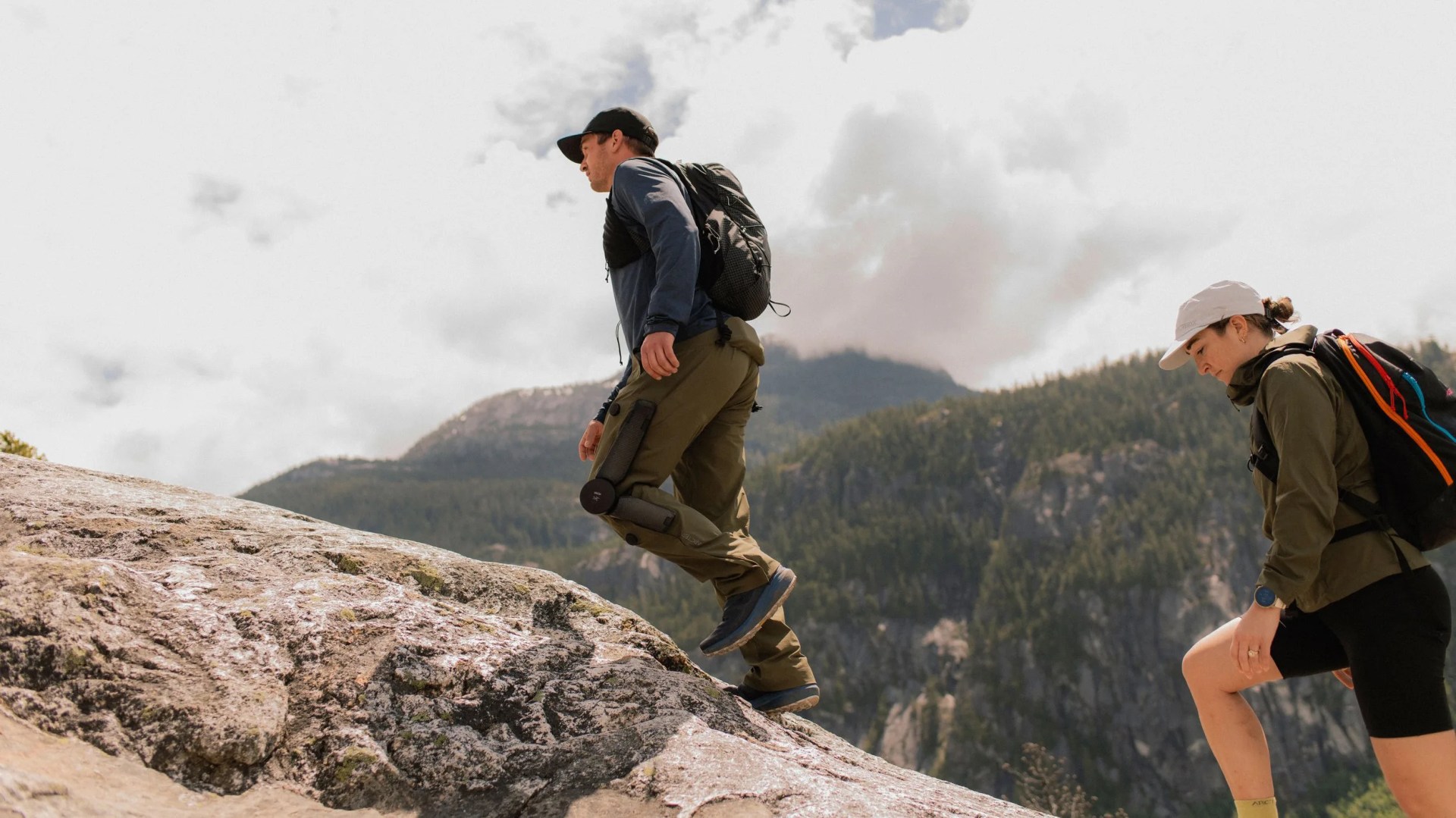 man hiking up a mountain with robotic pants