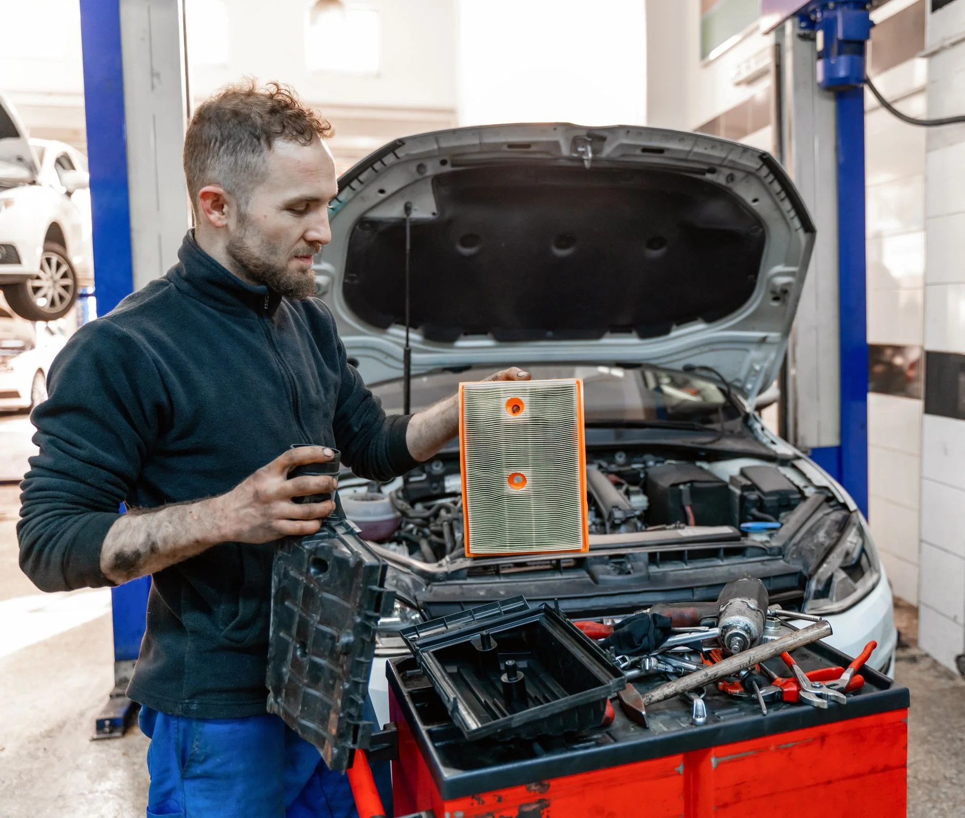 the auto mechanic replaces the car's air filter