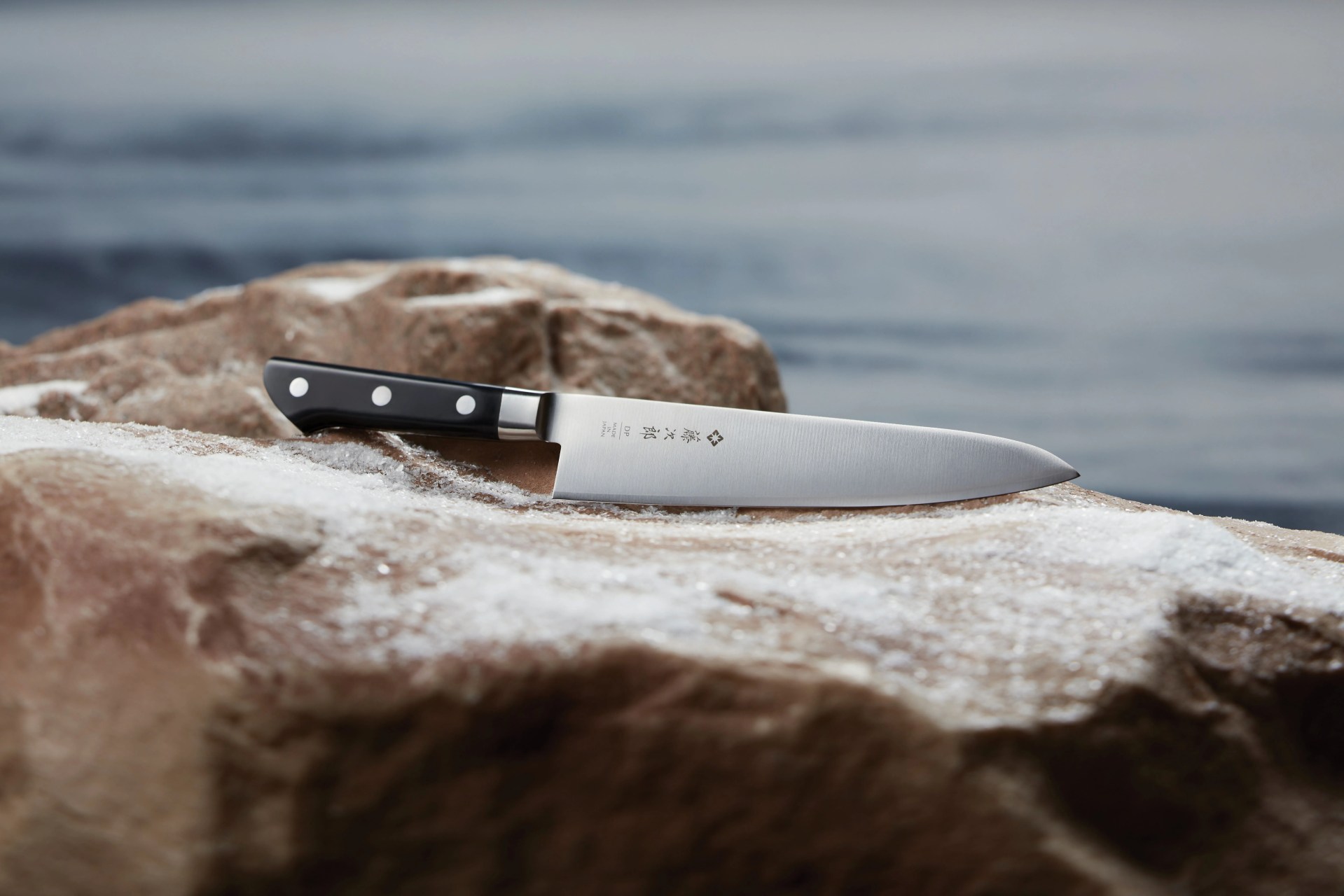 a kitchen knife sitting on a rock