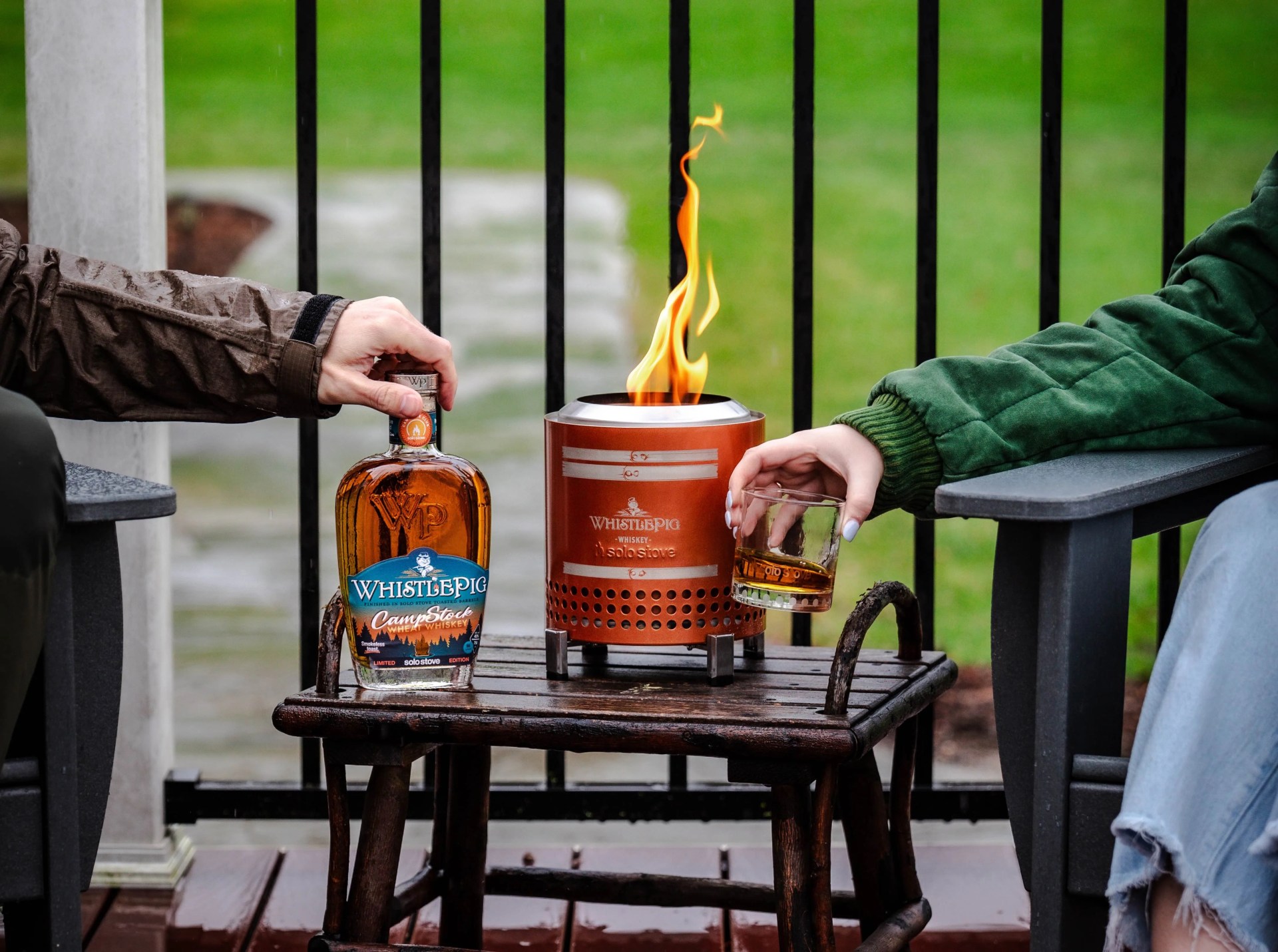 people drinking whistlepig whiskey next to a solo stove fire pit on a table